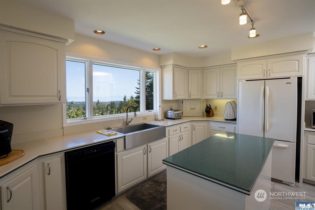 150 Quails Roost Road Sequim, WA 98382 - Photo 14 of 31 a kitchen with a refrigerator a sink and cabinets