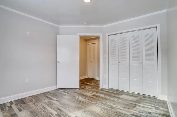 a view of an empty room with wooden floor