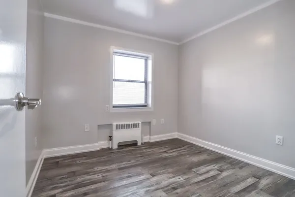 a view of a room with wooden floor and window