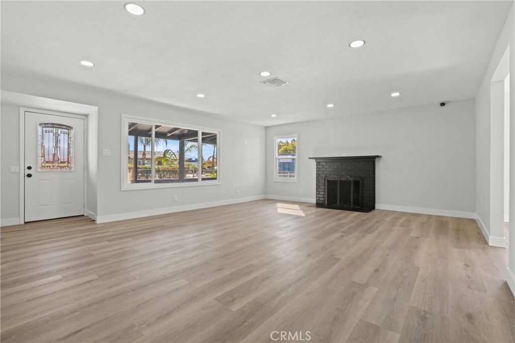 1116 7th Street Calimesa, CA 92320 - Photo 8 of 52 a view of empty room with wooden floor and fireplace