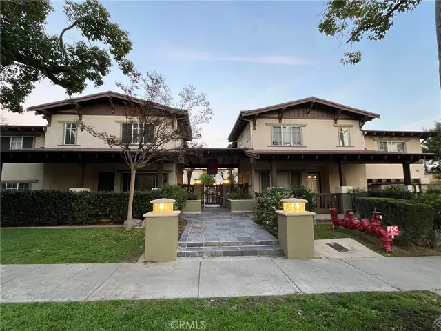 a front view of a house with a garden and a tree