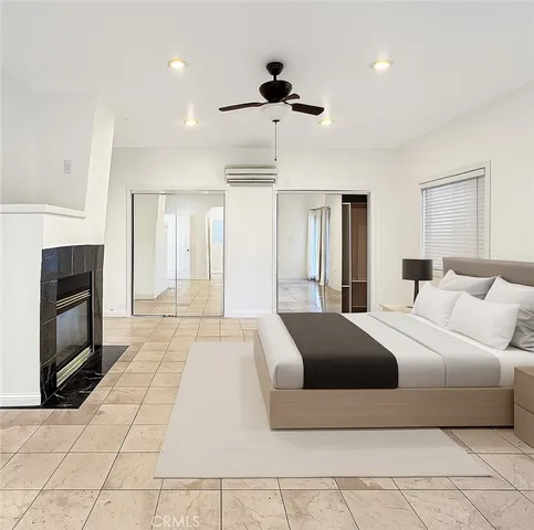 a bedroom with a large bed and a fireplace