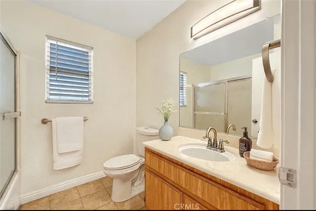a bathroom with a granite countertop sink toilet a mirror and shower