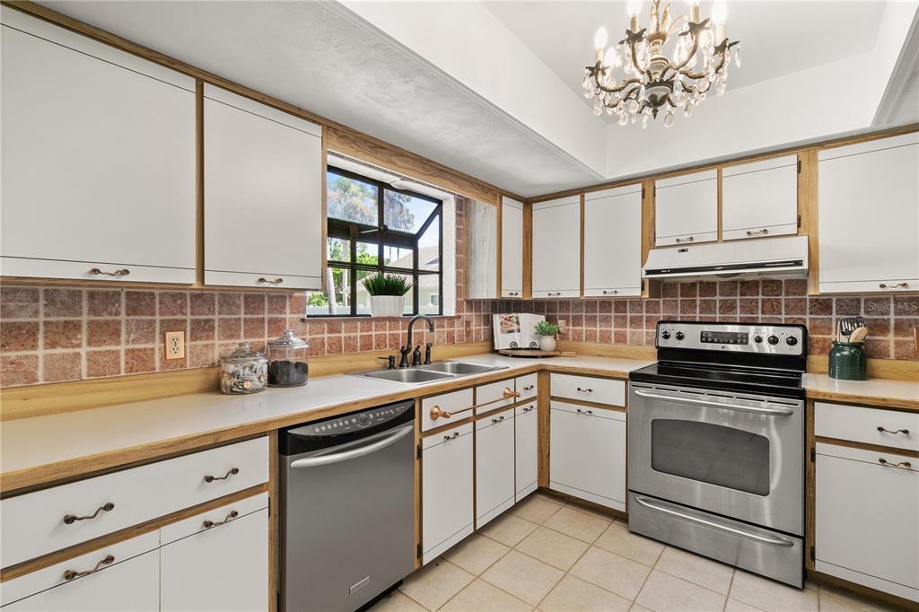 100 Bittern Court Daytona Beach, FL 32119 - Photo 13 of 52 a kitchen with a sink stove and cabinets