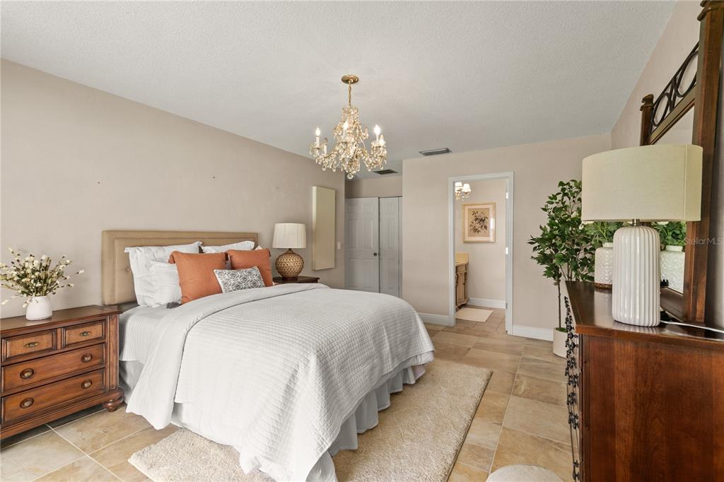 100 Bittern Court Daytona Beach, FL 32119 - Photo 19 of 52 a bedroom with a bed and a chandelier