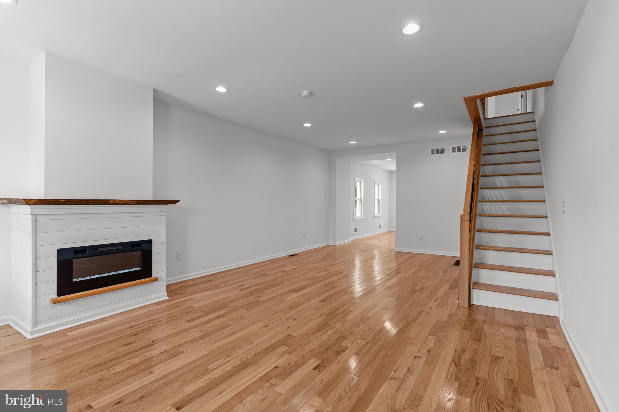 446 Pond Street Bristol, PA 19007 - Photo 7 of 35 a view of an empty room with wooden floor fireplace and a window