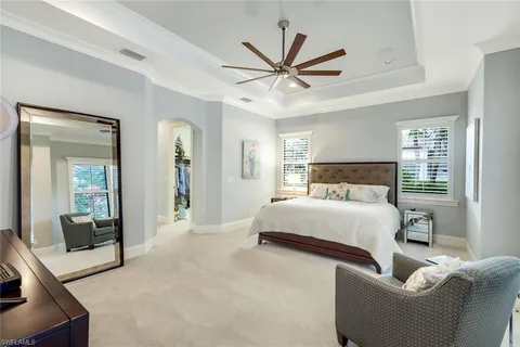 a bedroom with a large bed and a chandelier