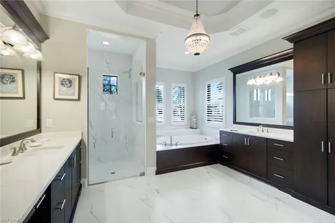 a spacious bathroom with a tub sink shower and mirror