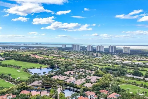 an aerial view of residential houses with outdoor space and trees