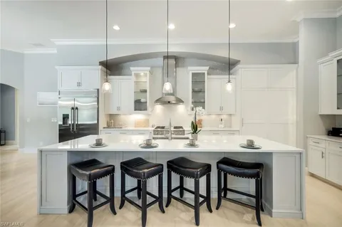 a kitchen with stainless steel appliances kitchen island a table and chairs in it