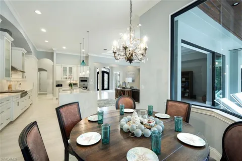 a view of a dining room with furniture a chandelier and wooden floor