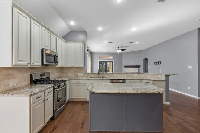 a kitchen with stainless steel appliances granite countertop a sink stove microwave and cabinets