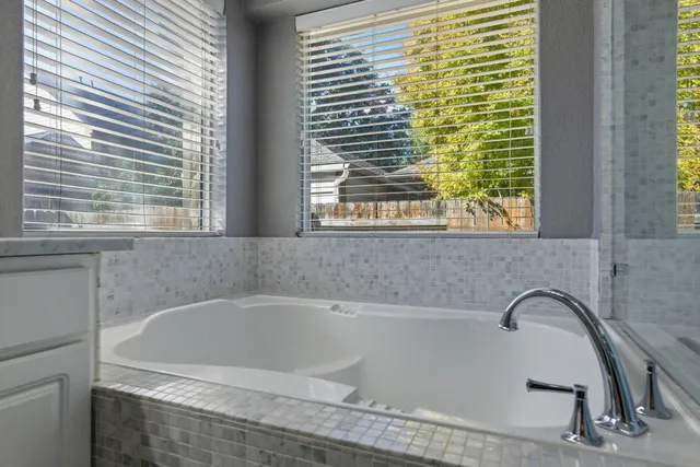 a bath tub sitting in a bathroom next to a window