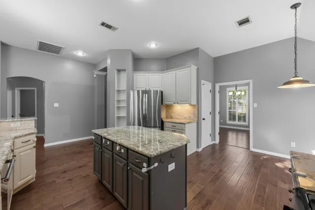 a kitchen with a table chairs refrigerator and microwave