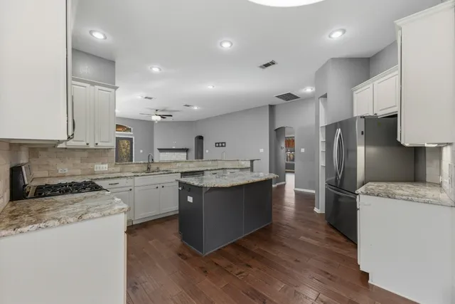 a large kitchen with stainless steel appliances lots of counter space sink and a refrigerator
