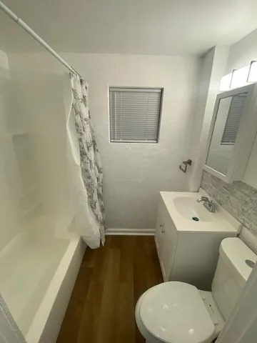 a white toilet sitting next to a bathroom sink and a shower