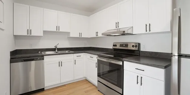 a kitchen with stainless steel appliances granite countertop a sink stove and cabinets