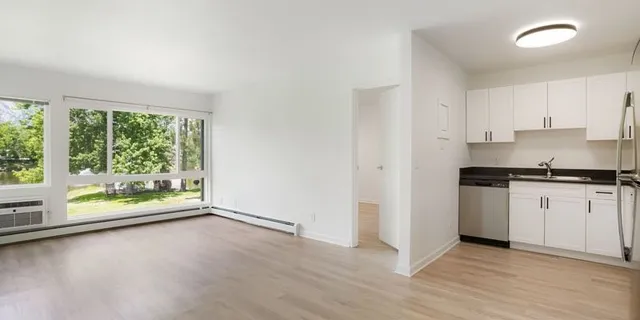 an empty room with wooden floor and a window