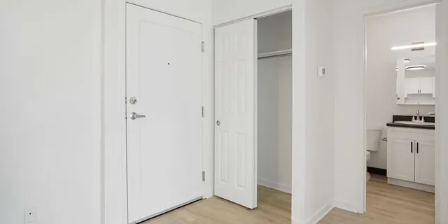 a view of a kitchen with white cabinets