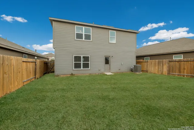 a view of a backyard with potted plants and large tree