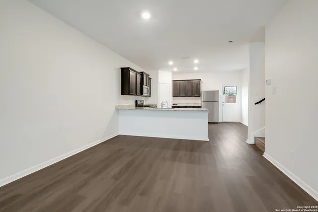 a view of a kitchen with a sink a microwave and cabinets