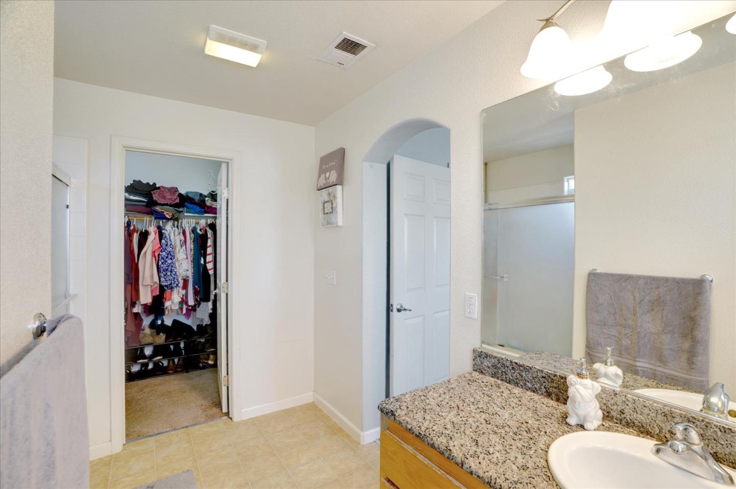 15525 Watsonville Road Morgan Hill, CA 95037 - Photo 29 of 36 a bathroom with a granite countertop sink a mirror and a shower