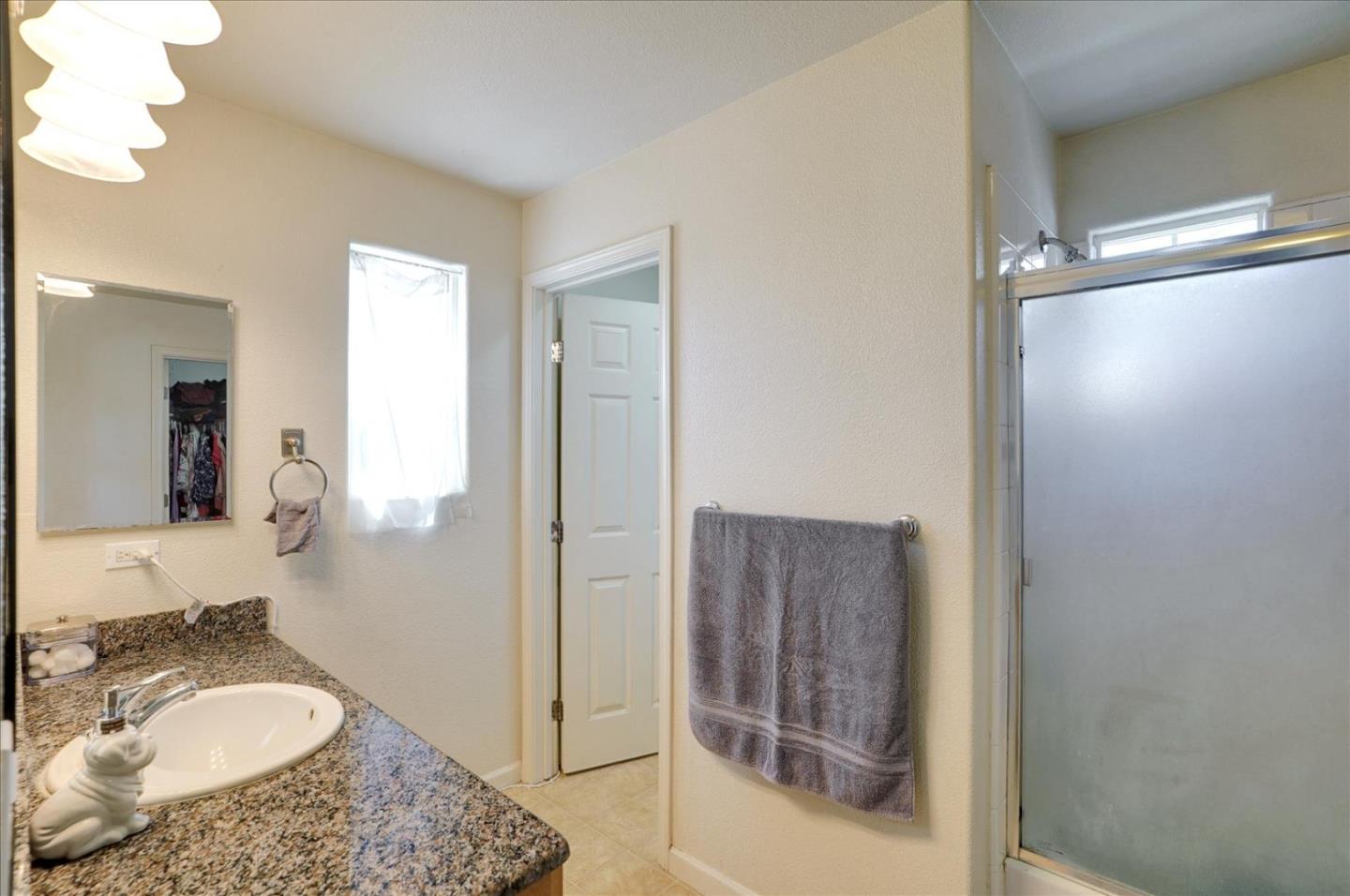 15525 Watsonville Road Morgan Hill, CA 95037 - Photo 30 of 36 a bathroom with a granite countertop sink mirror and vanity