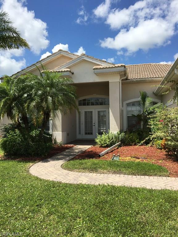 2161 Rusty Fig Court Naples, FL 34120 - Photo 1 of 17 a front view of a house with a garden and yard