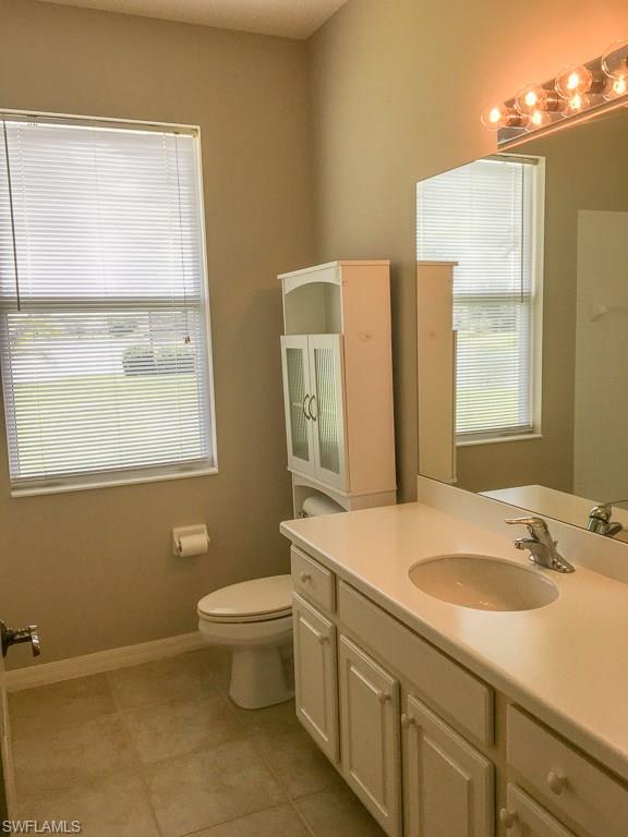 2161 Rusty Fig Court Naples, FL 34120 - Photo 14 of 17 a bathroom with a granite countertop sink toilet and mirror