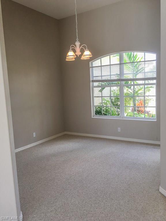 2161 Rusty Fig Court Naples, FL 34120 - Photo 10 of 17 an empty room with a window and chandelier