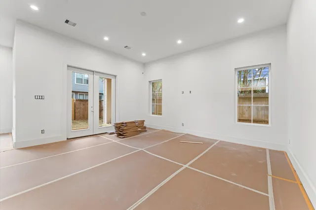 a view of an empty room with windows and entryway