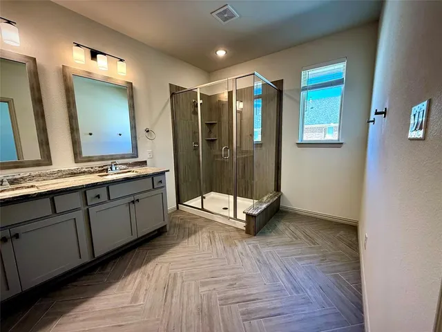 a bathroom with a double vanity sink and mirror