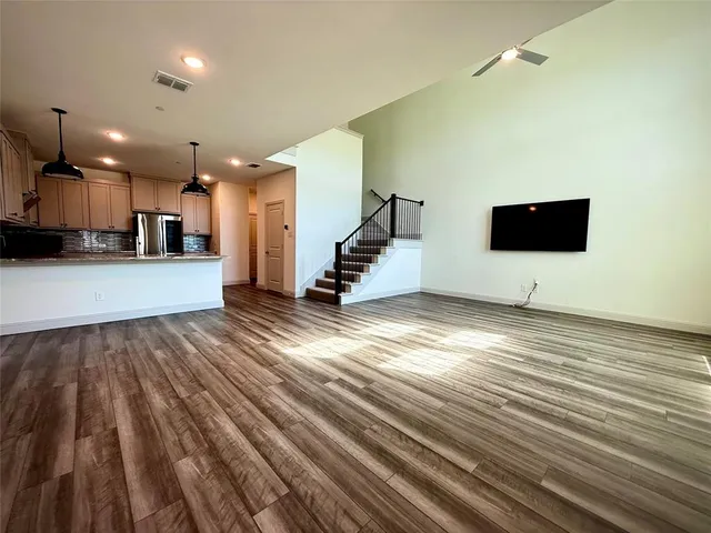 a view of a living room a kitchen island wooden floor and furniture