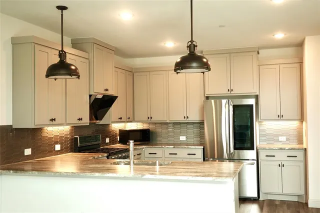 a kitchen with stainless steel appliances granite countertop a sink a stove and a refrigerator