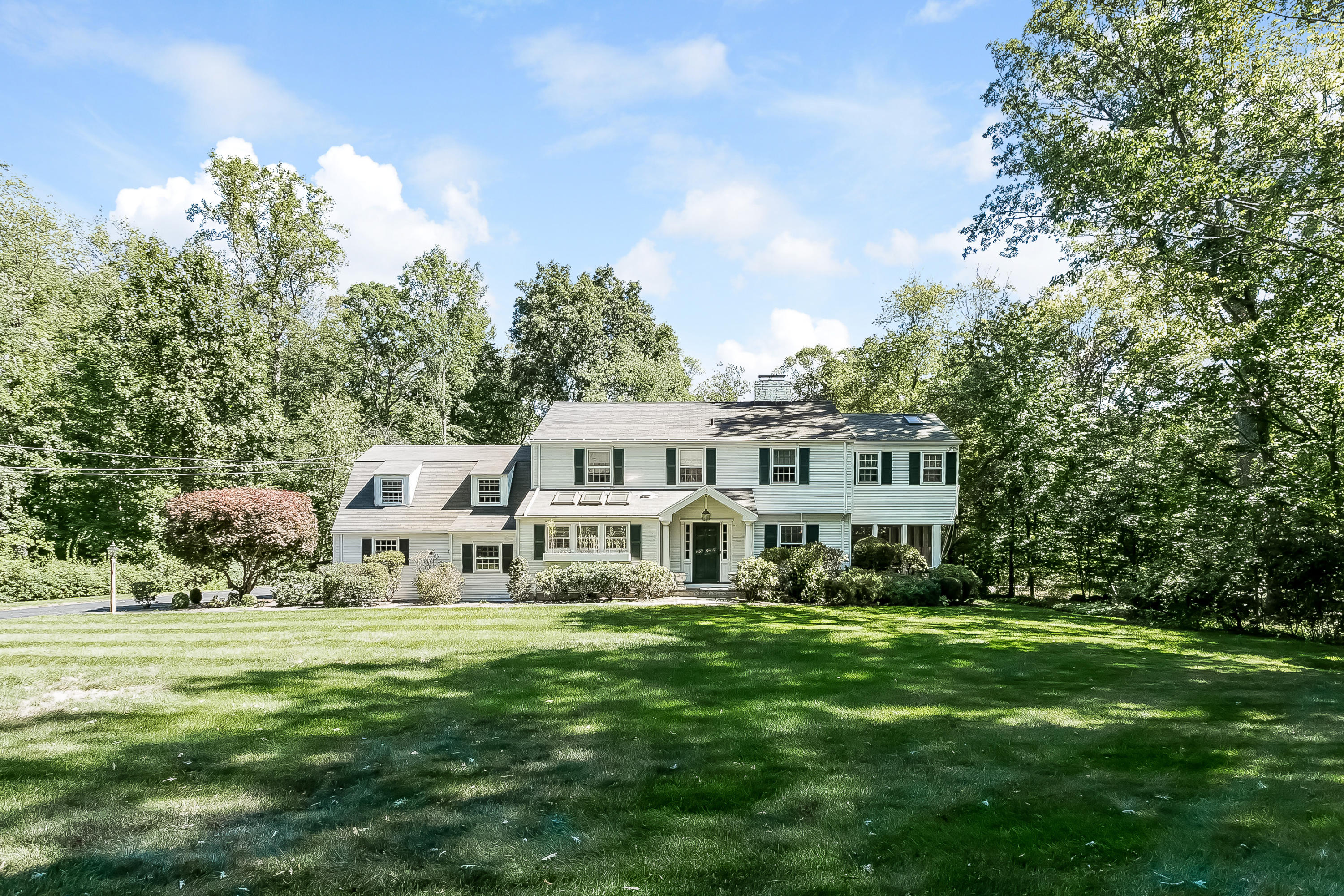32 Hillsley Road Darien, CT 06820 - Photo 1 of 20 a front view of a house with garden and trees
