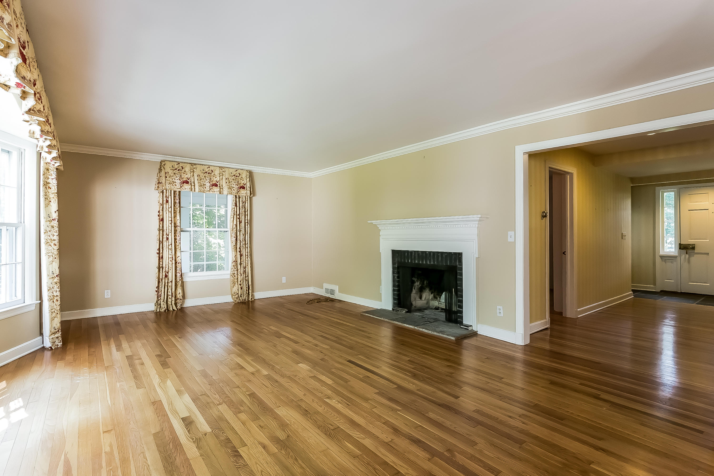 32 Hillsley Road Darien, CT 06820 - Photo 3 of 20 an empty room with wooden floor and fireplace