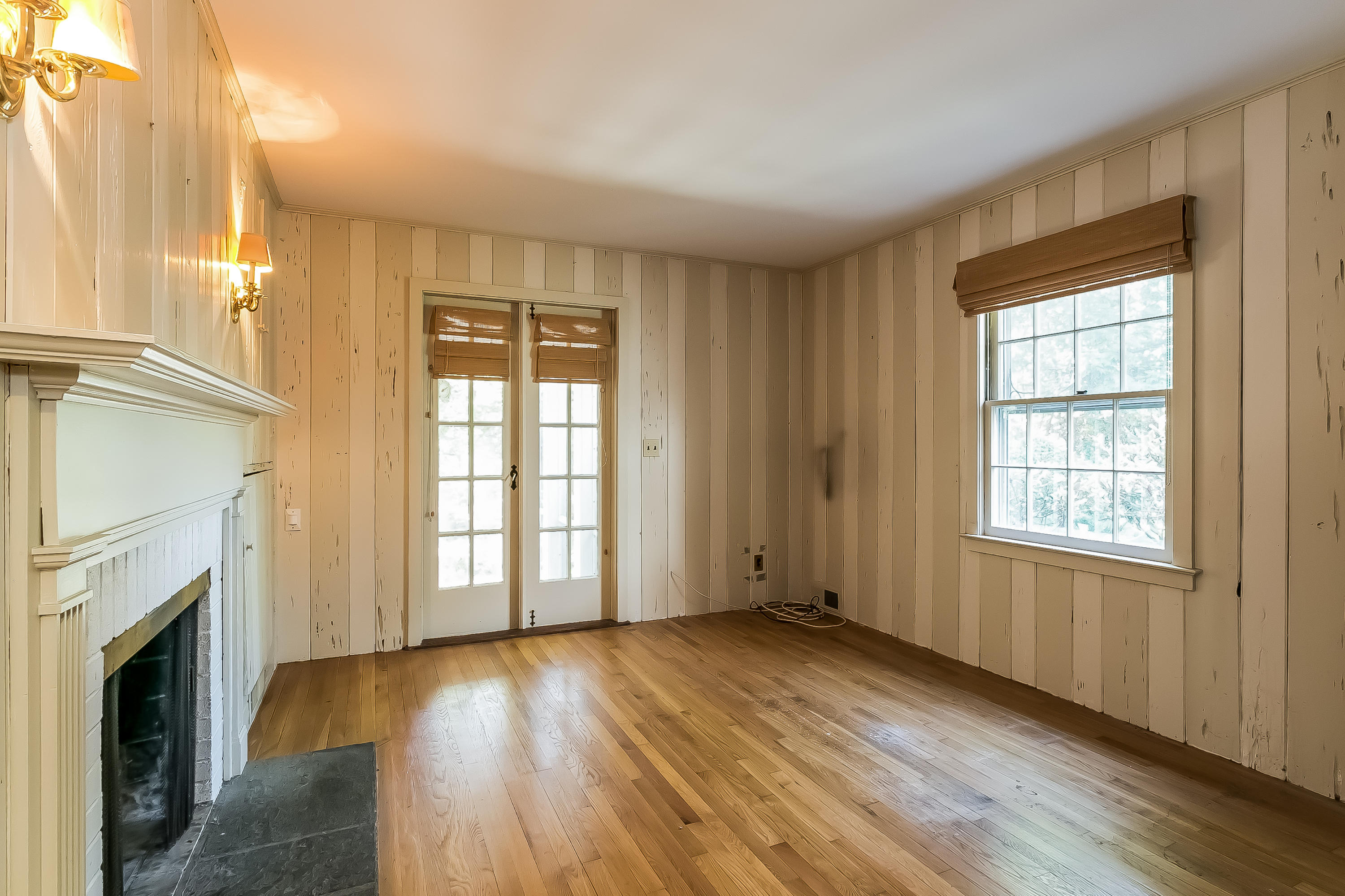 32 Hillsley Road Darien, CT 06820 - Photo 6 of 20 an empty room with wooden floor fireplace and windows