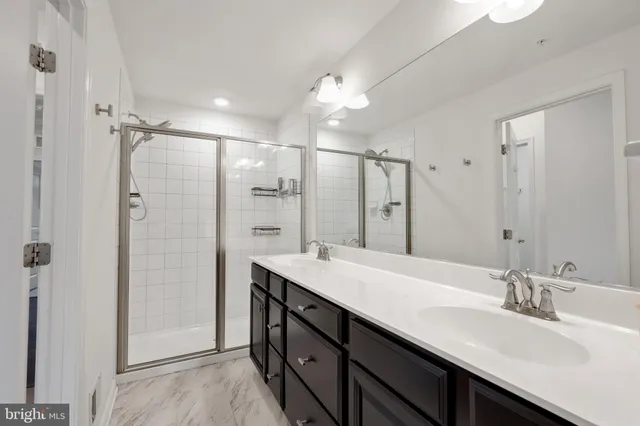 a bathroom with a double vanity sink mirror and shower
