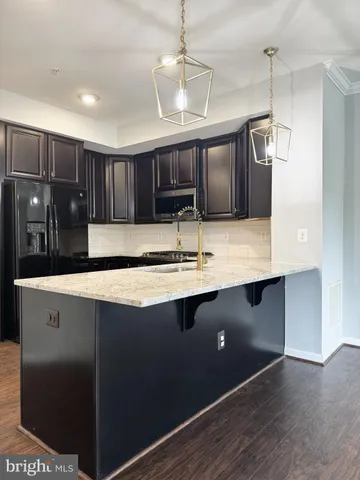 a living room with stainless steel appliances kitchen island granite countertop a sink cabinets and wooden floor