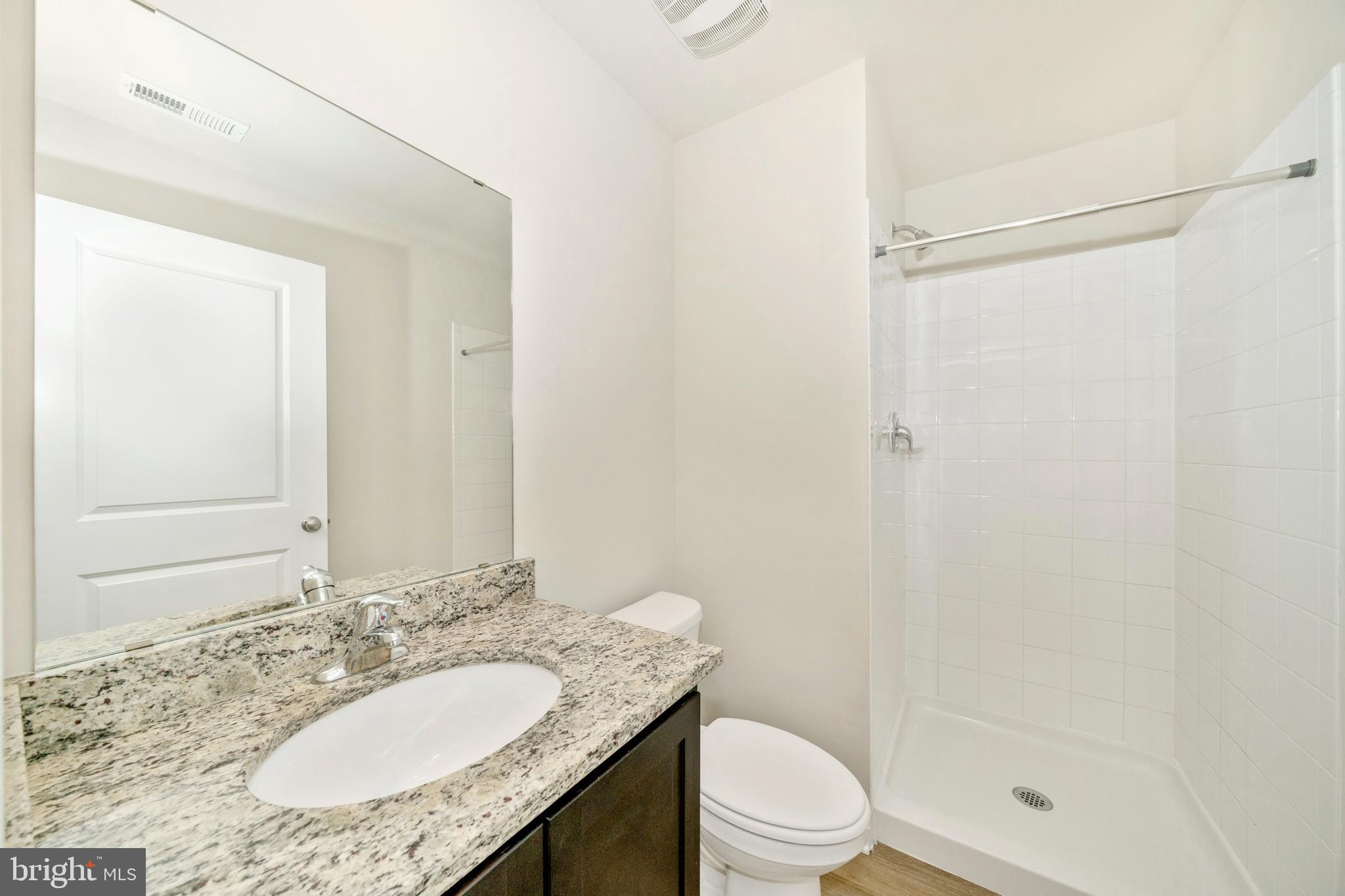 8634 Walter Martz Road Frederick, MD 21702 - Photo 18 of 52 a bathroom with a granite countertop sink toilet mirror and shower