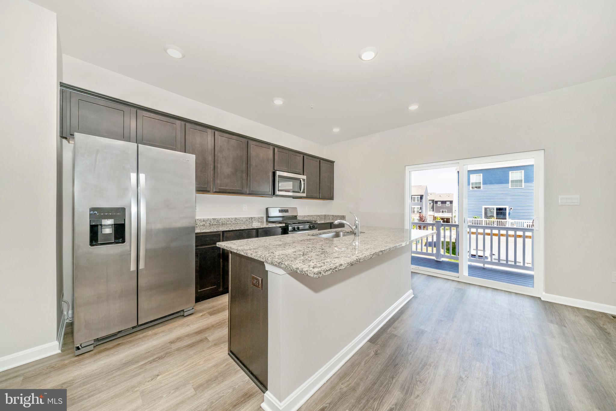 8634 Walter Martz Road Frederick, MD 21702 - Photo 3 of 52 a kitchen with stainless steel appliances granite countertop a refrigerator a sink dishwasher and a stove with wooden floors