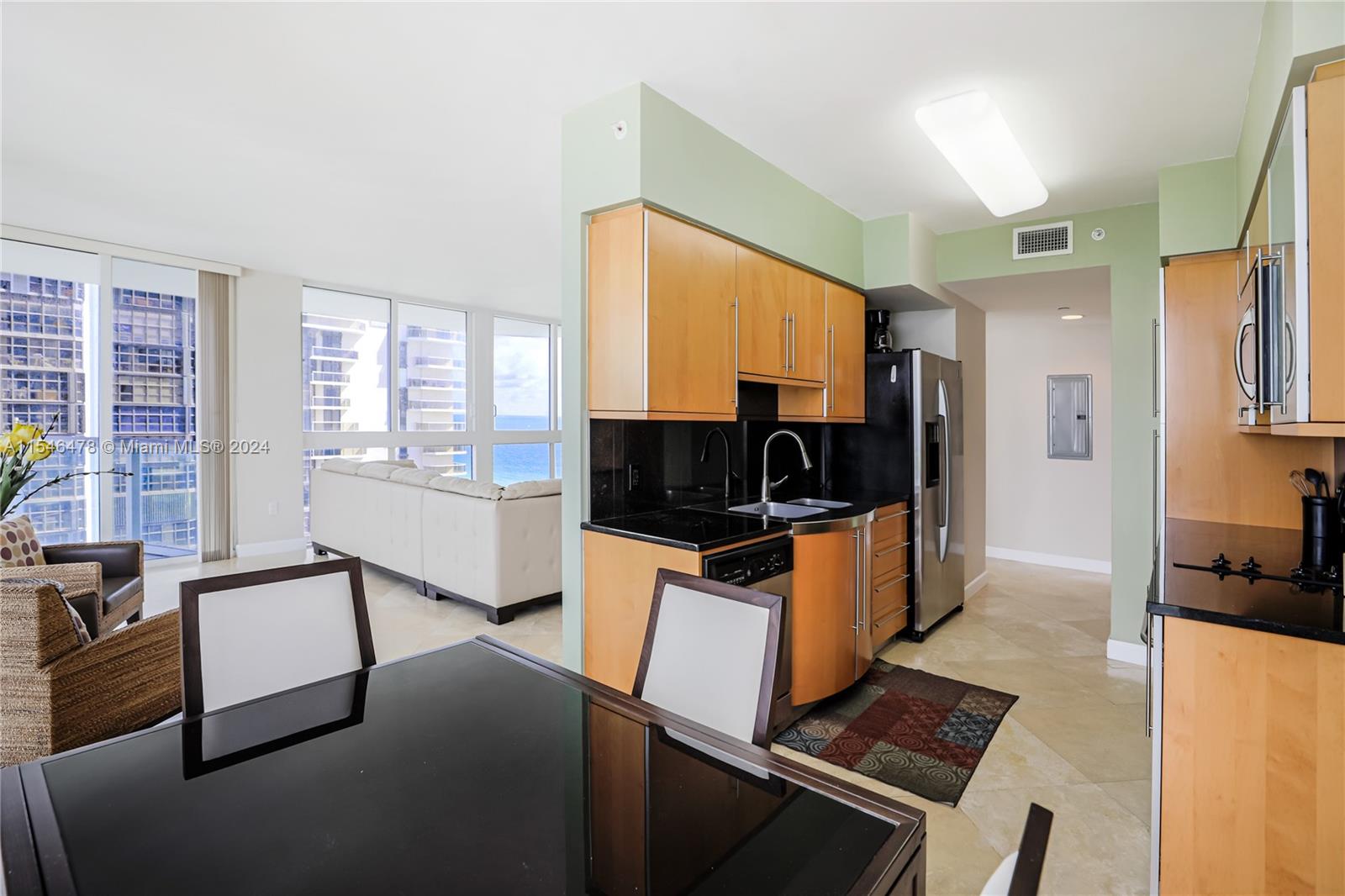 6365 Collins Avenue, Unit 1408 Miami Beach, FL 33141 - Photo 26 of 37 a living room with furniture a flat screen tv and a refrigerator