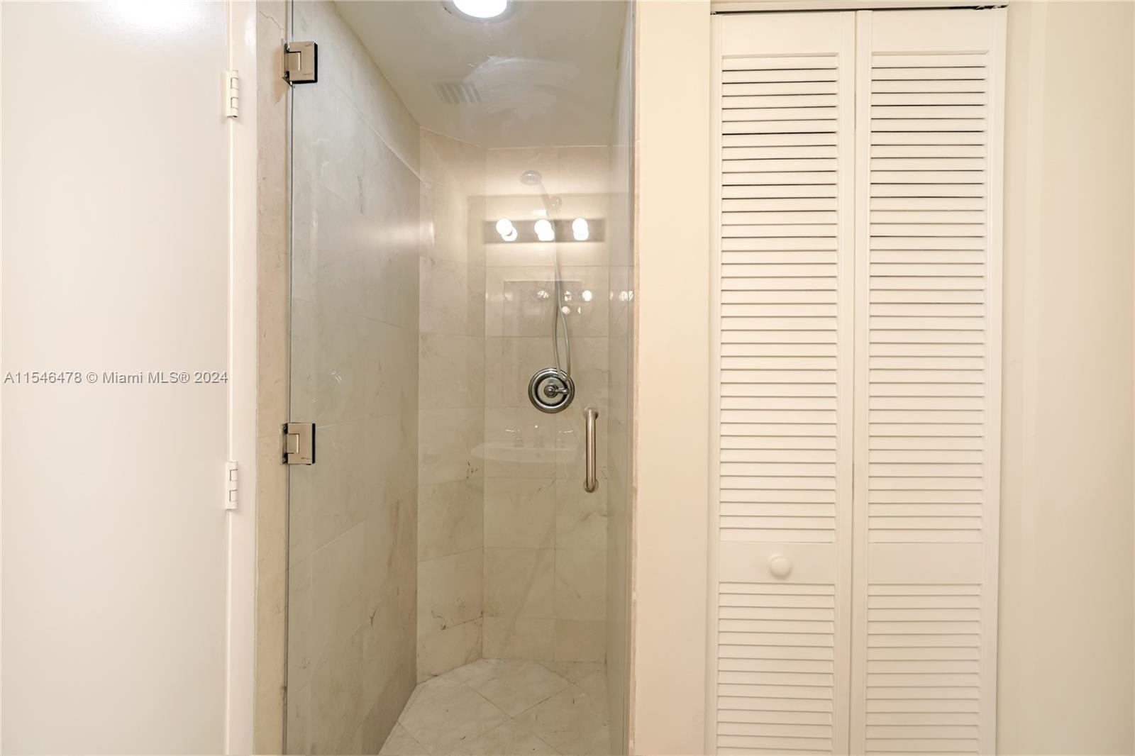 6365 Collins Avenue, Unit 1408 Miami Beach, FL 33141 - Photo 34 of 37 a bathroom with a shower and a window