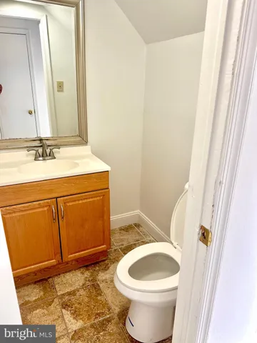 a bathroom with a granite countertop toilet and a sink