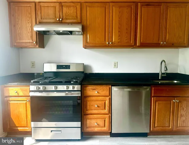 a kitchen with stainless steel appliances granite countertop a stove and a microwave