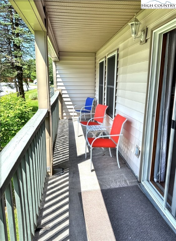 301 Pinnacle Inn Road, Unit 2105 Beech Mountain, NC 28604 - Photo 15 of 23 a balcony with wooden floor stairs and a bench