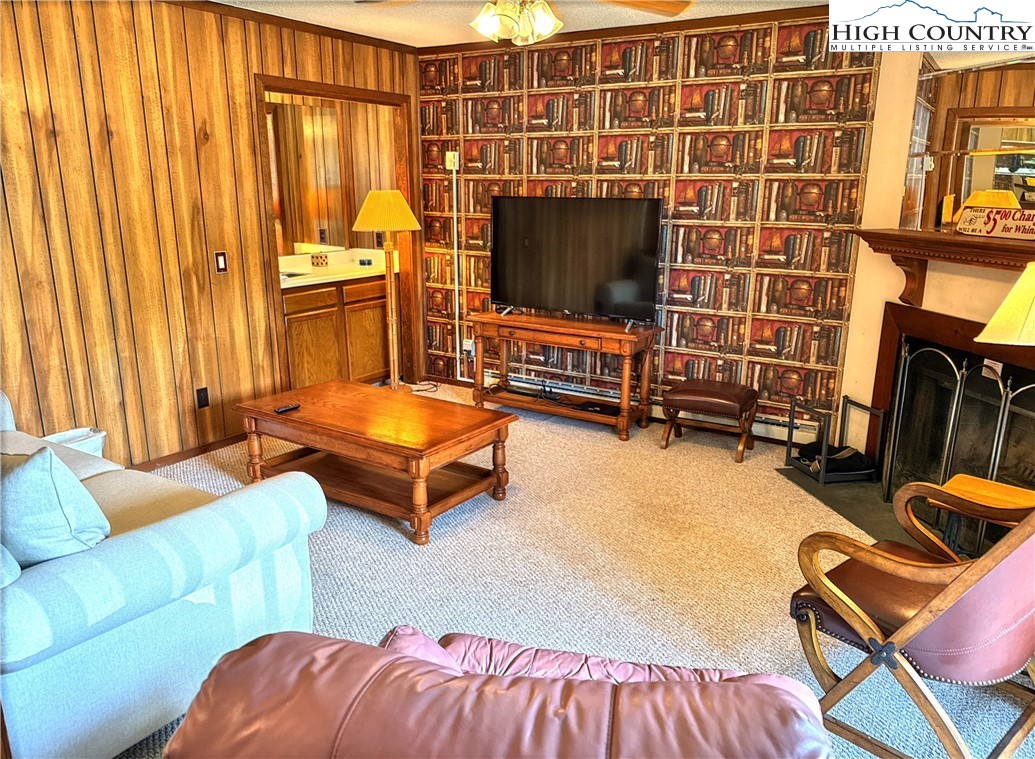 301 Pinnacle Inn Road, Unit 2105 Beech Mountain, NC 28604 - Photo 3 of 23 a living room with furniture a flat screen tv and a fireplace