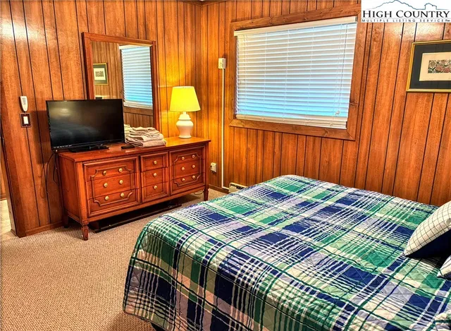 a bedroom with a bed and flat screen tv