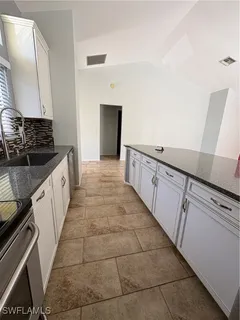 a kitchen with granite countertop a sink and cabinets