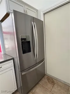 a close view of a refrigerator and a stove in kitchen
